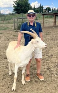 Pate McCartney at an animal sanctuary petting a white goat.