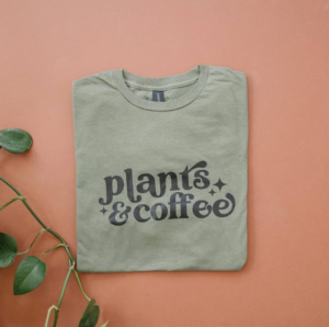 A sage green T-Shirt with 'Plants & Coffee'